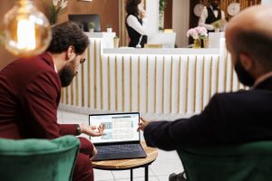 Entrepreneurs exchange ideas to work together on corporate partnership, travelling on work trip to forge alliances with corporations. Attending business meeting in lounge area at luxury hotel.